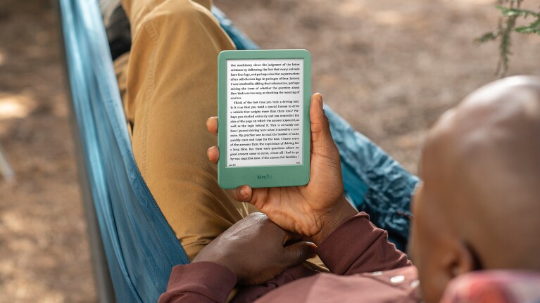 Person reading Kindle e-reader while relaxing in hammock