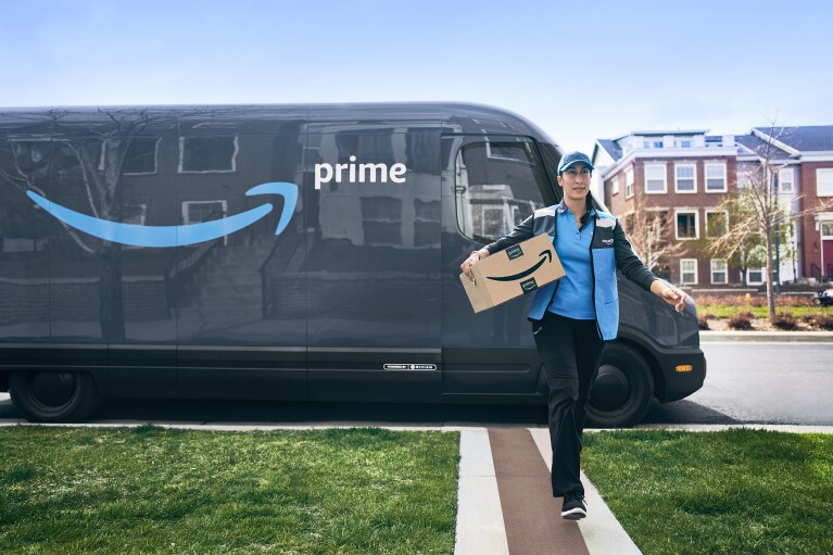Amazon Prime delivery driver carrying package in front of branded van