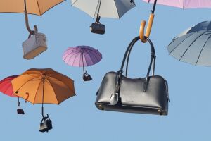 Colorful umbrellas and handbags floating against blue sky