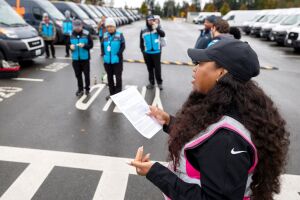 Amazon Delivery Service Partner addressing group of workers in blue vests in parking lot