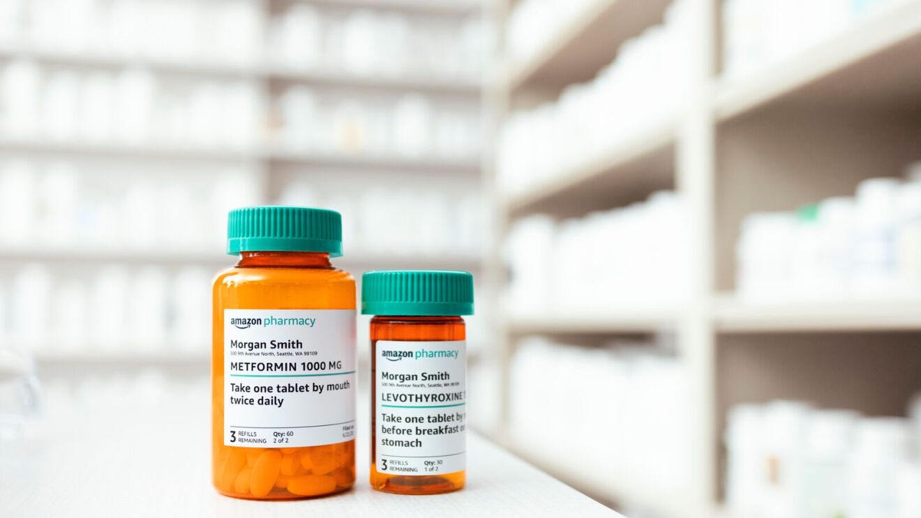 Two orange medication bottles with teal caps on pharmacy shelf from Amazon Pharmacy