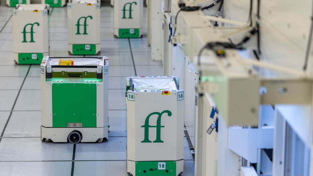 Automated robots with 'ff' logo in warehouse-like setting